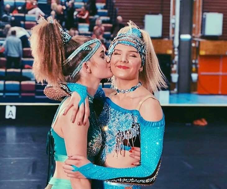 En tjej ger en annan tjej en puss på kinden efter dansnummer